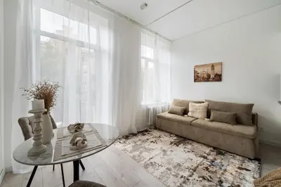 a living room with a couch and a glass table at Šopeno Butas Comfort & Relax in Old Town 2 in Vilnius