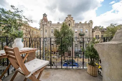 a balcony with a table and a view of a building at Šopeno Butas Comfort & Relax in Old Town 2 in Vilnius