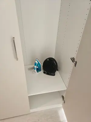 a white cabinet with a helmet sitting on a shelf at Šopeno Butas Comfort & Relax in Old Town 2 in Vilnius