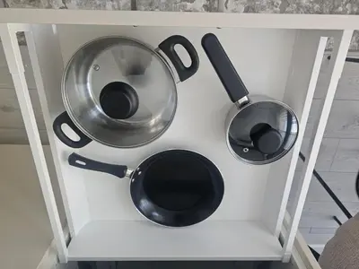 two pots and pans on a white shelf at Šopeno Butas Comfort & Relax in Old Town 2 in Vilnius
