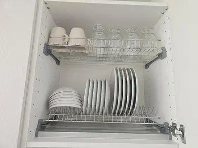 a cupboard with plates and bowls on a shelf at Šopeno Butas Comfort & Relax in Old Town 2 in Vilnius