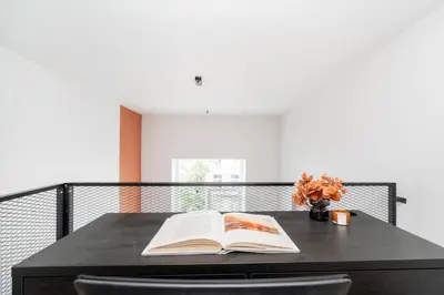 an open book on a black table with a vase of flowers at Vytenio Loft - Serenity and Style in City Centre 23 in Vilnius
