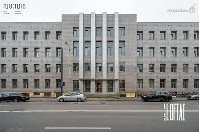a large building with cars parked in front of it at Vytenio Loft - Serenity and Style in City Centre 23 in Vilnius