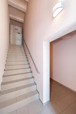 a hallway with stairs in a building with a light at Apartment Accent by Polo Apartments in Kaunas