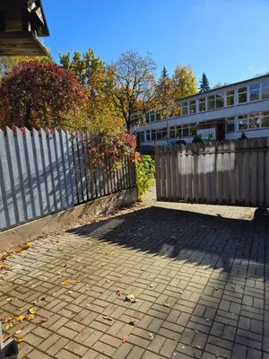 a fence and a brick sidewalk next to a building at Bistrycia in Vilnius