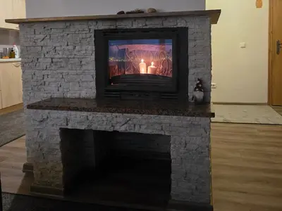 a stone fireplace with a tv on top of it at Bistrycia in Vilnius