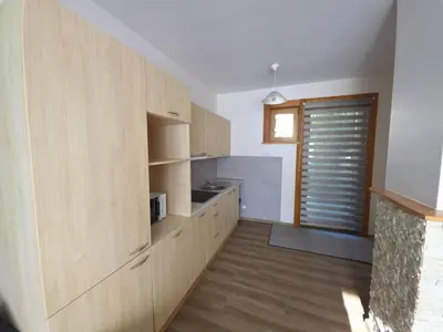 a large kitchen with wooden cabinets and a window at Bistrycia in Vilnius