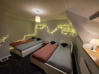 two beds in a room with lights on the wall at Bistrycia in Vilnius