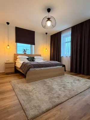 a bedroom with a large bed and a large window at Crown Apartment Park View in Ukmergė