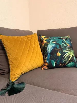 two pillows on a couch with a bird on it at Crown Apartment Park View in Ukmergė
