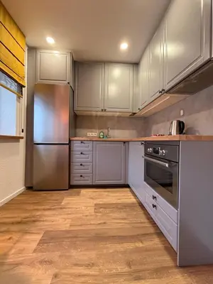 a kitchen with white cabinets and stainless steel appliances at Crown Apartment Park View in Ukmergė