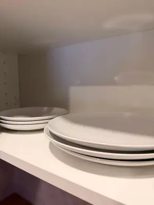 three stacks of plates sitting on a counter in a kitchen at Crown Apartment Park View in Ukmergė