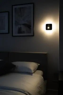 a bedroom with a bed and a light on the wall at Cozy 4 Two - City Center Apartment in Kaunas