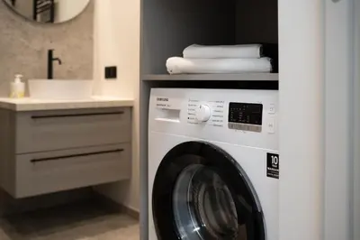 a washing machine in a bathroom with a sink at Cozy 4 Two - City Center Apartment in Kaunas
