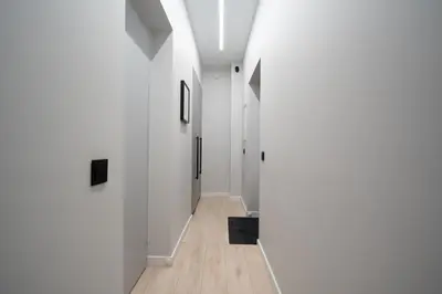 a hallway with white walls and wood floors at Cozy 4 Two - City Center Apartment in Kaunas