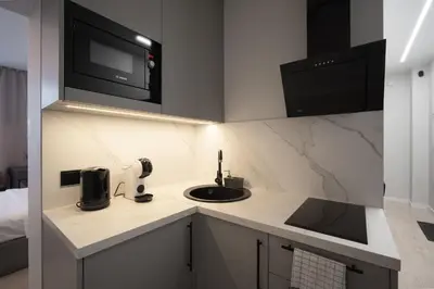 a kitchen with a sink and a microwave at Cozy 4 Two - City Center Apartment in Kaunas