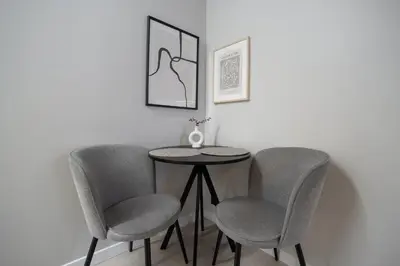 a table with two chairs and a table with a vase on it at Cozy 4 Two - City Center Apartment in Kaunas