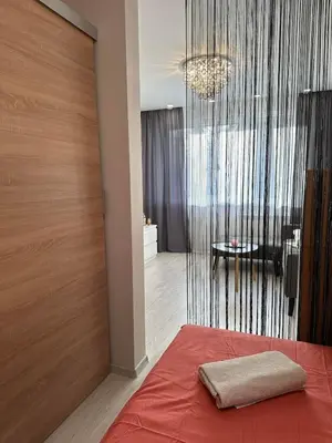 a bedroom with a bed with a red blanket at Newly renovated cosy apartment near scenic river in Jonava