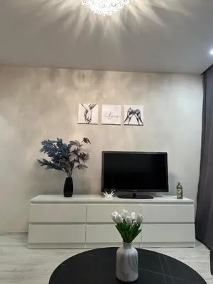 a living room with a television and a table at Newly renovated cosy apartment near scenic river in Jonava