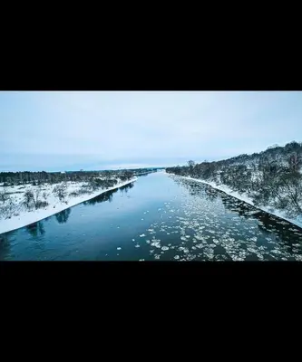a river with snow on the sides of it at Newly renovated cosy apartment near scenic river in Jonava