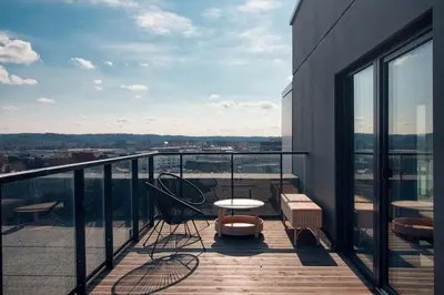 a balcony with a table and chairs on a building at Terrace Apartment near Ozas in Vilnius