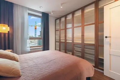 a bedroom with a large bed and a window at Terrace Apartment near Ozas in Vilnius