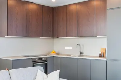 a kitchen with wooden cabinets and a sink at Terrace Apartment near Ozas in Vilnius