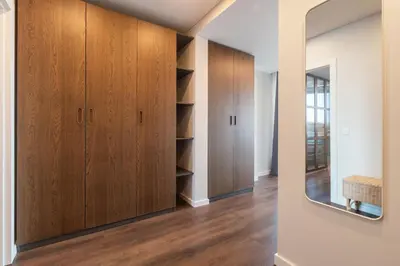 a room with wooden cabinets and a mirror at Terrace Apartment near Ozas in Vilnius