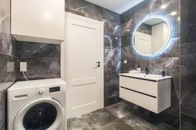 a bathroom with a washing machine and a sink at Terrace Apartment near Ozas in Vilnius