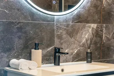 a bathroom with a sink and a mirror at Terrace Apartment near Ozas in Vilnius