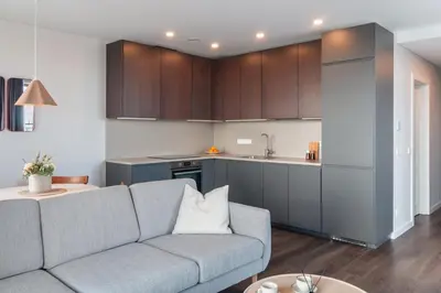 a living room with a couch and a kitchen at Terrace Apartment near Ozas in Vilnius