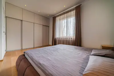 a bedroom with a large bed and a window at Marijonų Apartamentai in Panevėžys