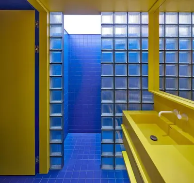 a bathroom with a yellow sink and blue tiles at Pop Haus Vilnius in Vilnius