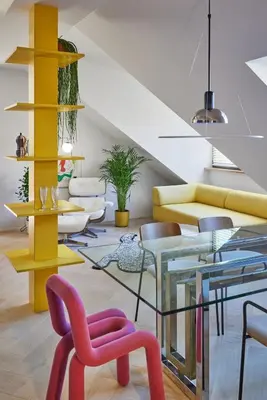 a living room with colorful chairs and a glass table at Pop Haus Vilnius in Vilnius