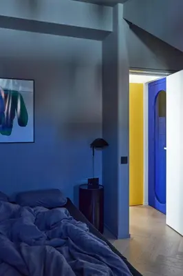 a bedroom with a bed and a blue wall at Pop Haus Vilnius in Vilnius