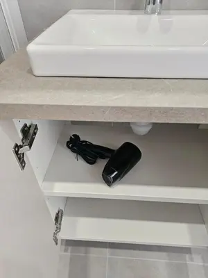 a bathroom counter with a sink and a black phone at Close to Old Town & Amenities 1 in Vilnius