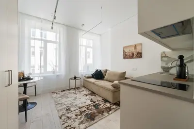 a white living room with a couch and a table at Close to Old Town & Amenities 1 in Vilnius
