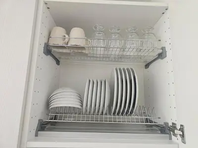 a closet with a shelf with plates and glass dishes at Close to Old Town & Amenities 1 in Vilnius