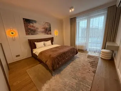 a bedroom with a bed and a large window at Luxury Oasis in the Heart of the City in Druskininkai