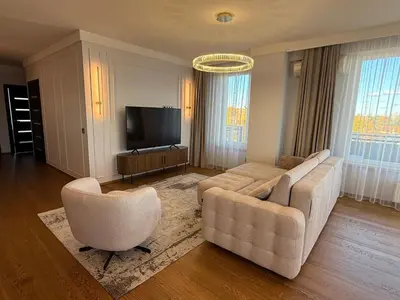 a living room with a couch and two chairs and a television at Luxury Oasis in the Heart of the City in Druskininkai