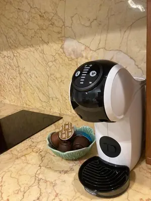 a coffee maker on a counter next to a cup of chocolate at Luxury Oasis in the Heart of the City in Druskininkai