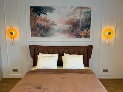a bedroom with a painting above a bed with two pillows at Luxury Oasis in the Heart of the City in Druskininkai