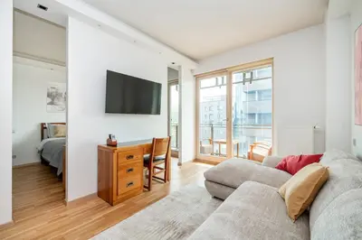 a living room with a couch and a tv on a wall at Studio in central Vilnius in Vilnius