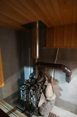 a stove with a bunch of logs in a kitchen at Peaceful lake retreat with sauna