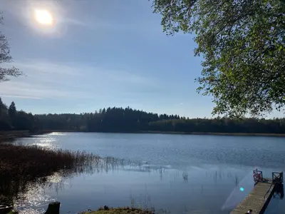 a view of a lake with the sun in the sky at Peaceful lake retreat with sauna