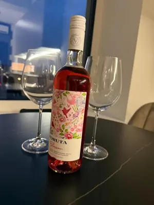 a bottle of wine sitting on a table with two wine glasses at Cosy apartment near city centre in Kaunas