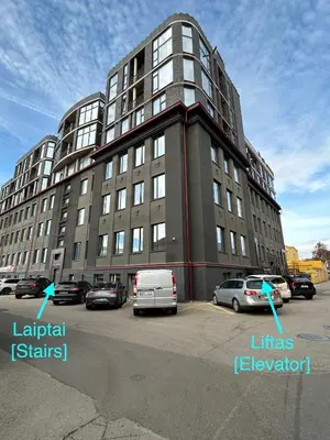 a large building with cars parked in a parking lot at Cosy apartment near city centre in Kaunas