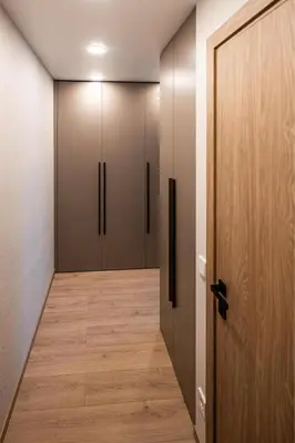 a hallway with four closet doors and a wooden floor at Vytauto 12 - jaukūs apartamentai centre - Self Check-in in Marijampolė