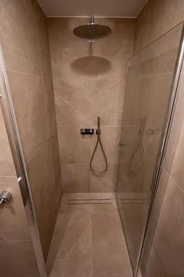 a bathroom with a shower with a glass door at Vytauto 12 - jaukūs apartamentai centre - Self Check-in in Marijampolė