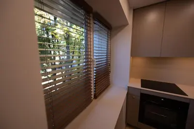 a kitchen with a large window with blinds on it at Vytauto 12 - jaukūs apartamentai centre - Self Check-in in Marijampolė
